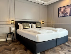 A modern bedroom with a large bed, two bedside lamps, and a framed artwork on the wall. - Boutique Hotel Zuckerfabrik (Stuttgart)