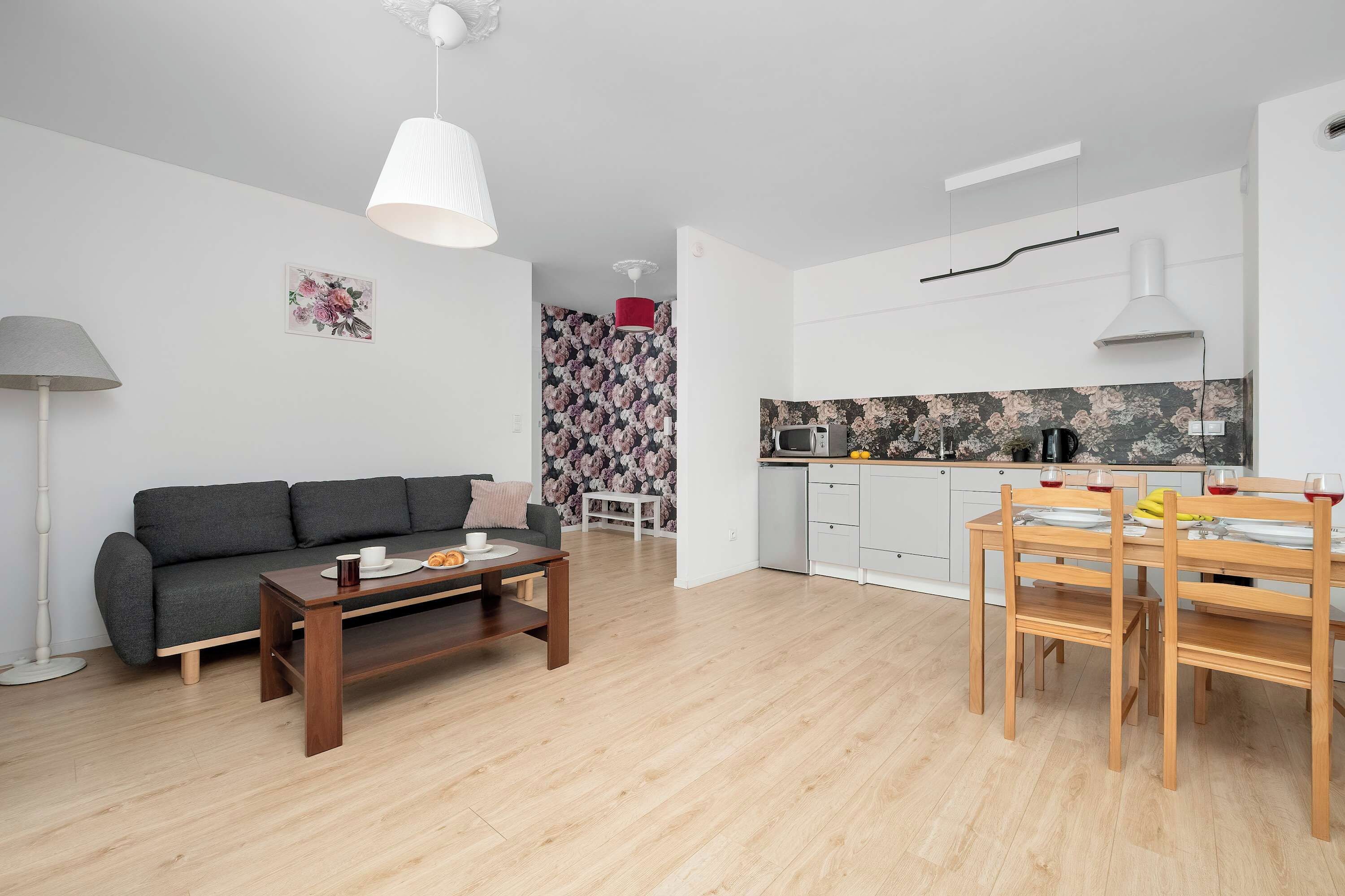 En moderne stue med sofa, sofabord og spiseplads med bord og stole.