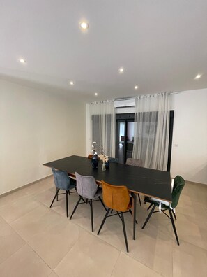 A dining area with a rectangular table, four chairs, and a vase with dried plants. - HOUSE WITH A SWIMMING POOL, AIR CONDITIONING, AND A LARGE GARDEN (Vierzon)