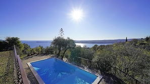 Piscina com vista para o mar e terra ao longe.