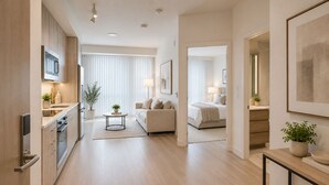 Een moderne hotelkamer met een kitchenette, een bed en een zithoek.