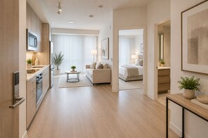 Una habitación de hotel moderna con kitchenette, cama y zona de estar.