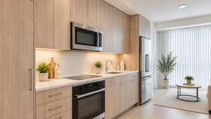 Een moderne keuken met houten kastjes, een Bosch magnetron, een roestvrijstalen koelkast en een inbouwoven.