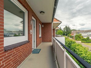 A residential building with a balcony, a door, and a window. - Apartment 6 "home Port" (St. Peter-Ording)