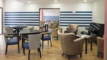 A dining area with striped walls, multiple tables, and chairs.