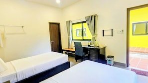 A hotel room with two beds, a desk, a chair, a window with curtains, and a door. - Sun Resort & Villa (Tien Thanh)