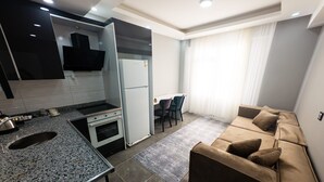 Cozinha moderna com forno embutido e área de jantar com mesa e cadeiras.