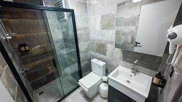Habitación doble Confort, balcón, vista a la ciudad | Baño | Regadera, regadera tipo lluvia, secadora de cabello, pantuflas