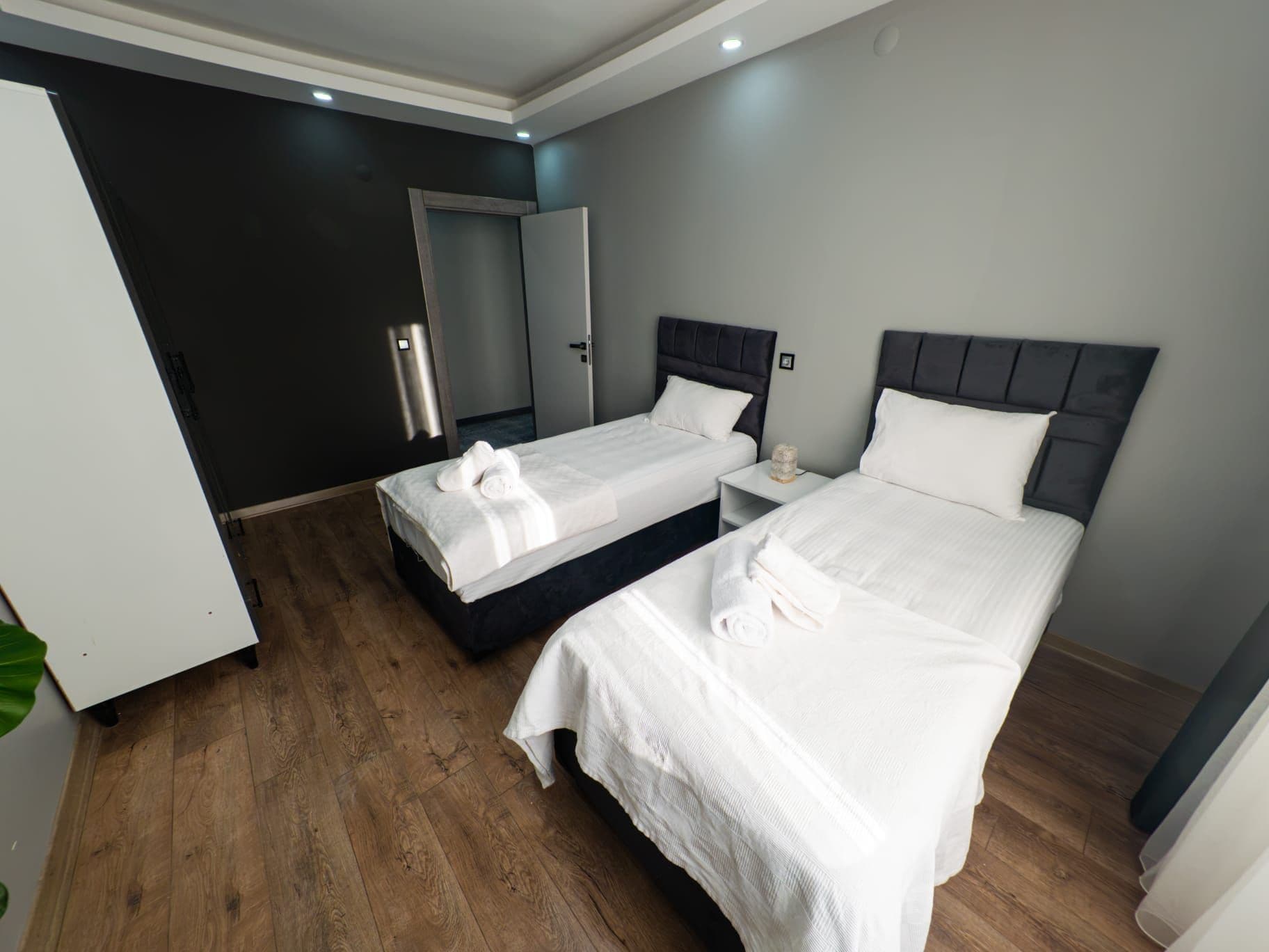 Una habitación de hotel con dos camas, un armario y un espejo.
