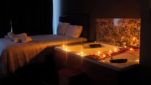 Um quarto com pouca luz, uma cama e uma banheira.