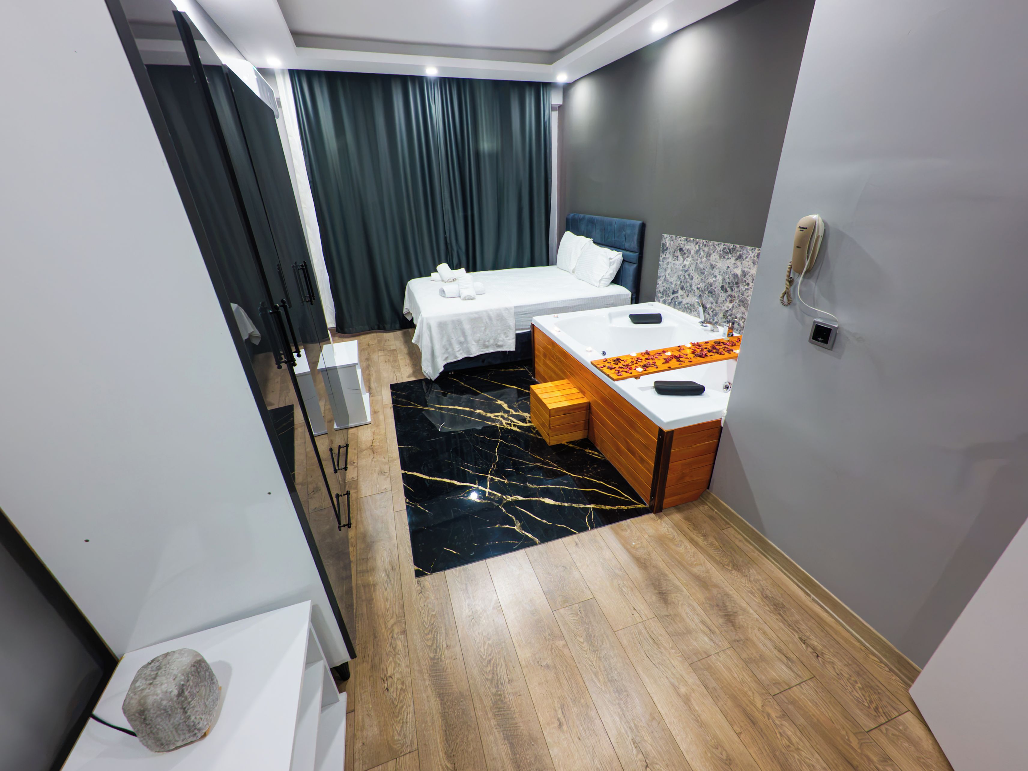 Una habitación de hotel moderna con cama, un escritorio pequeño, tocador y baño.
