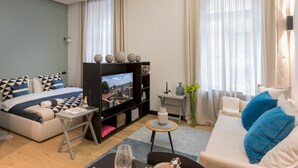 A modern living room with a sofa, a TV, and a coffee table. - G43 (Zagreb)