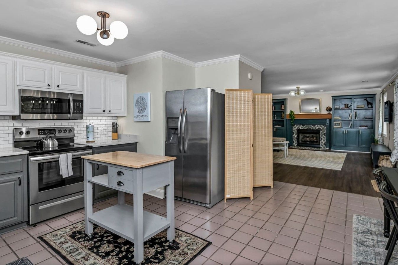 A modern kitchen with white cabinetry, stainless steel appliances, and a central island.
