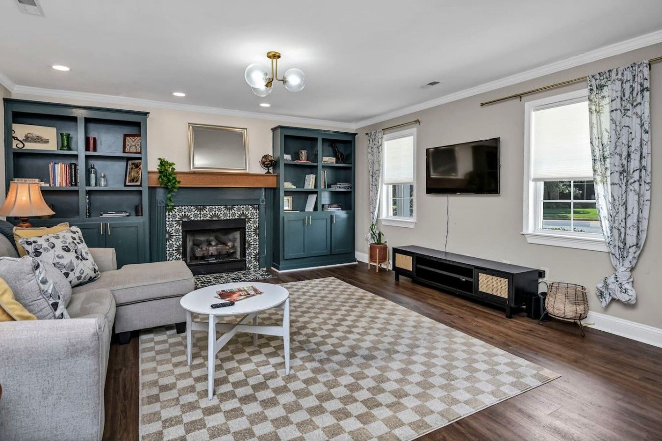 A living room with a fireplace, a sofa, a coffee table, and a TV.