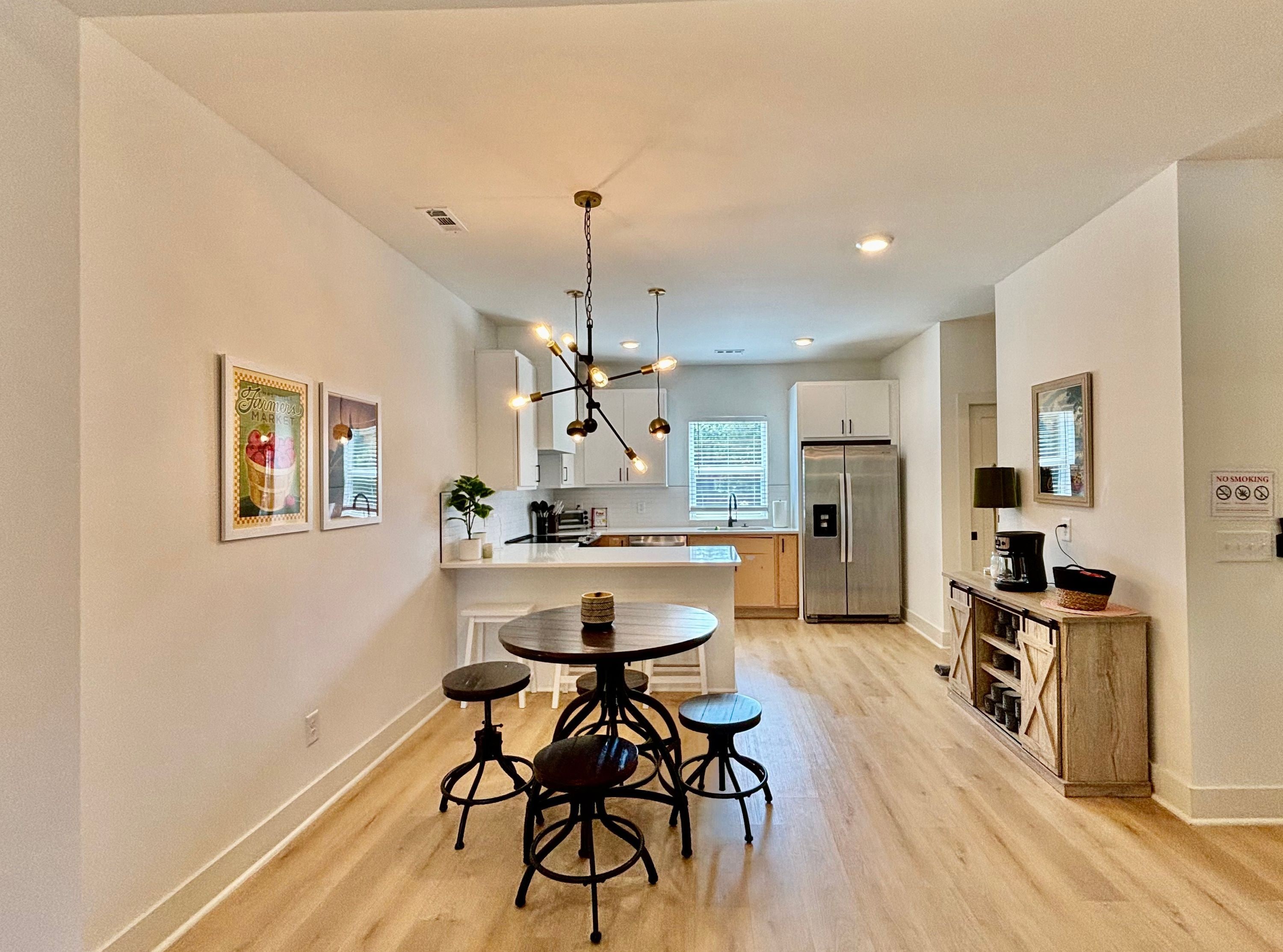 A modern kitchen with a central island, stainless steel appliances, and pendant lighting.