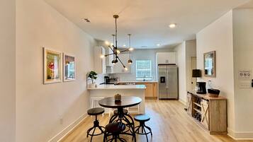A modern kitchen with a central island, stainless steel appliances, and pendant lighting.