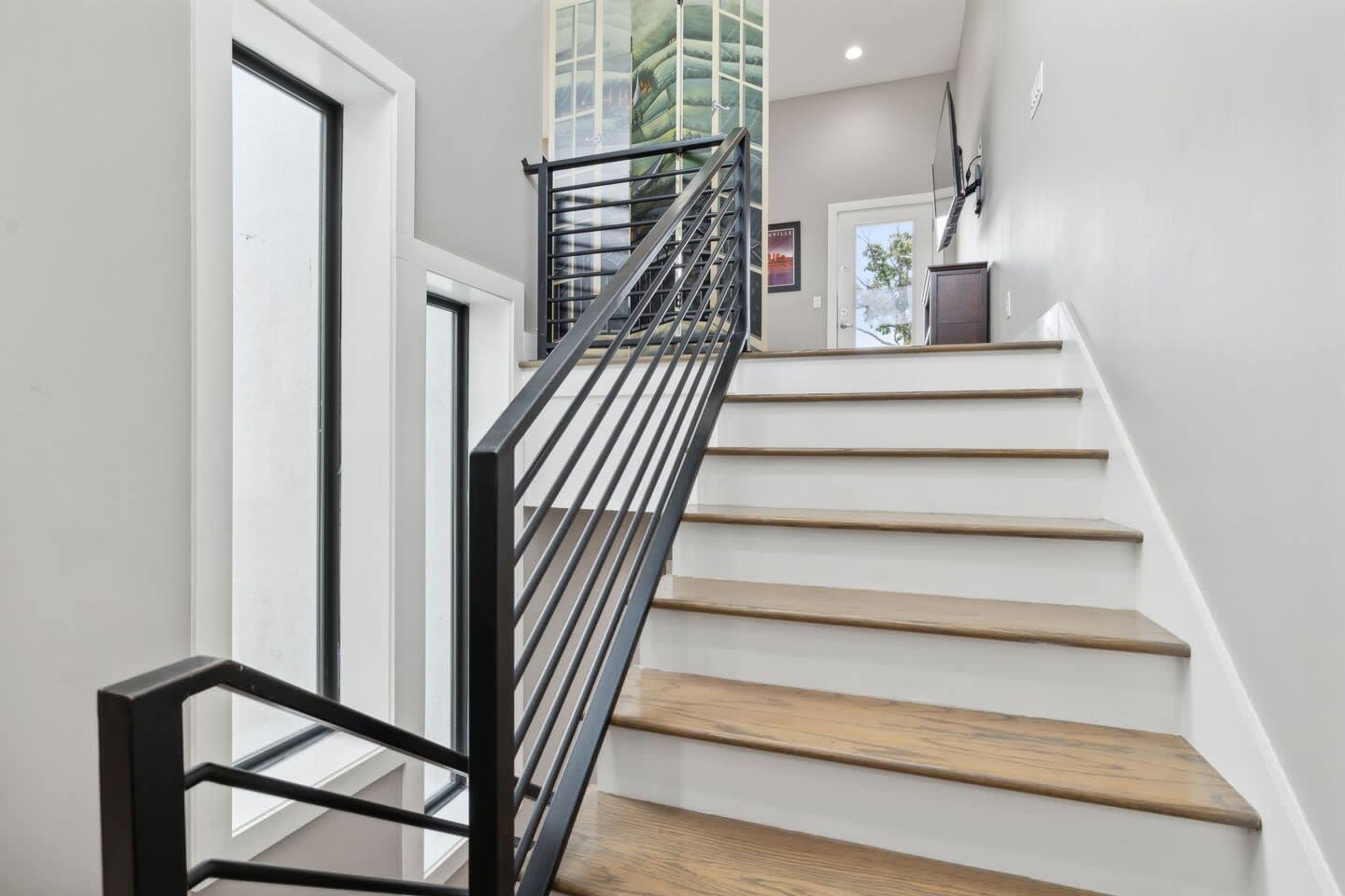 A staircase with wooden steps and a black metal railing.