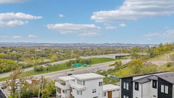 A residential area with modern houses, a highway, and a clear sky.