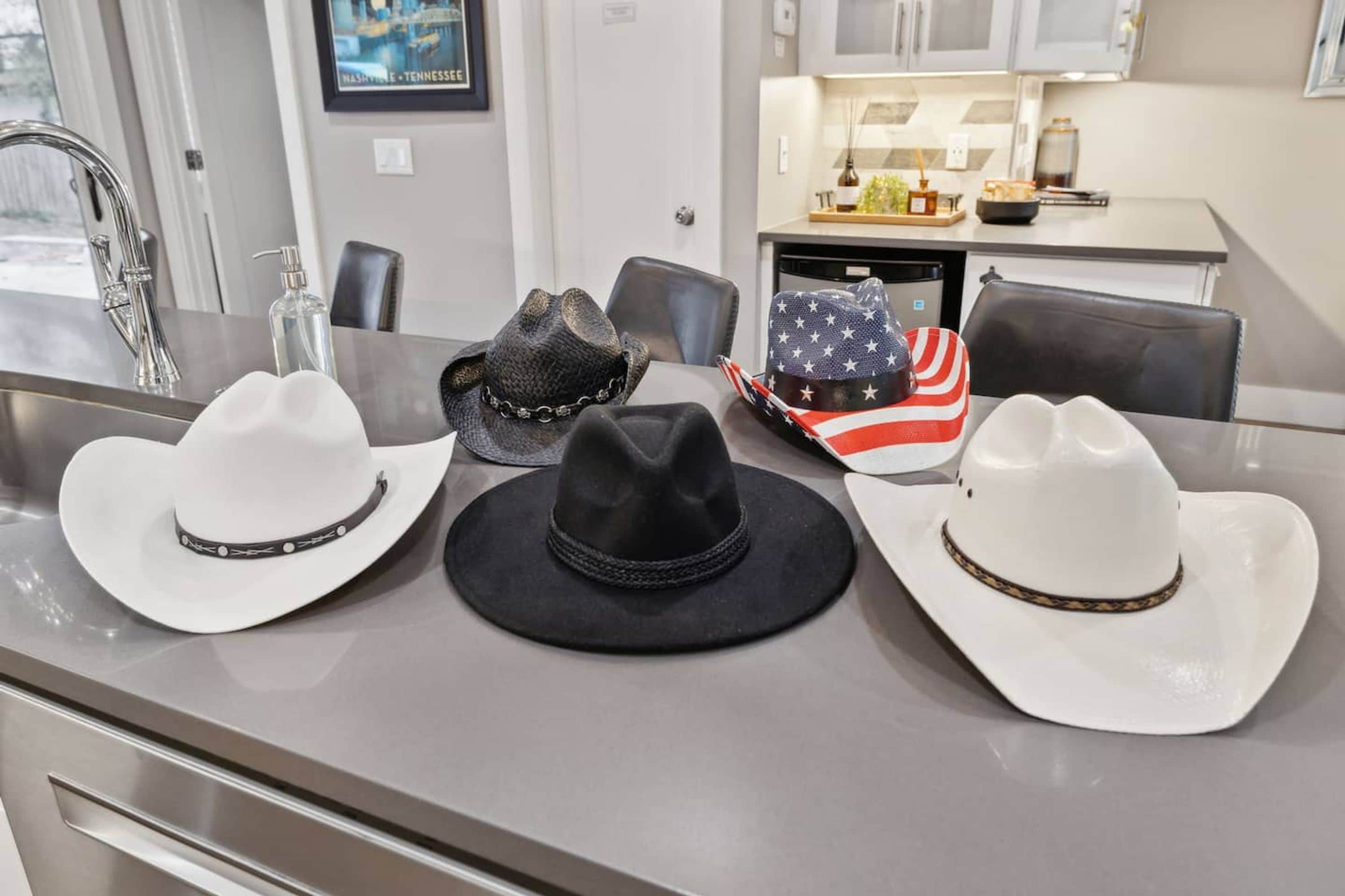 En matplats med en disk i rostfritt stål, tre cowboyhattar och ett kök i bakgrunden.