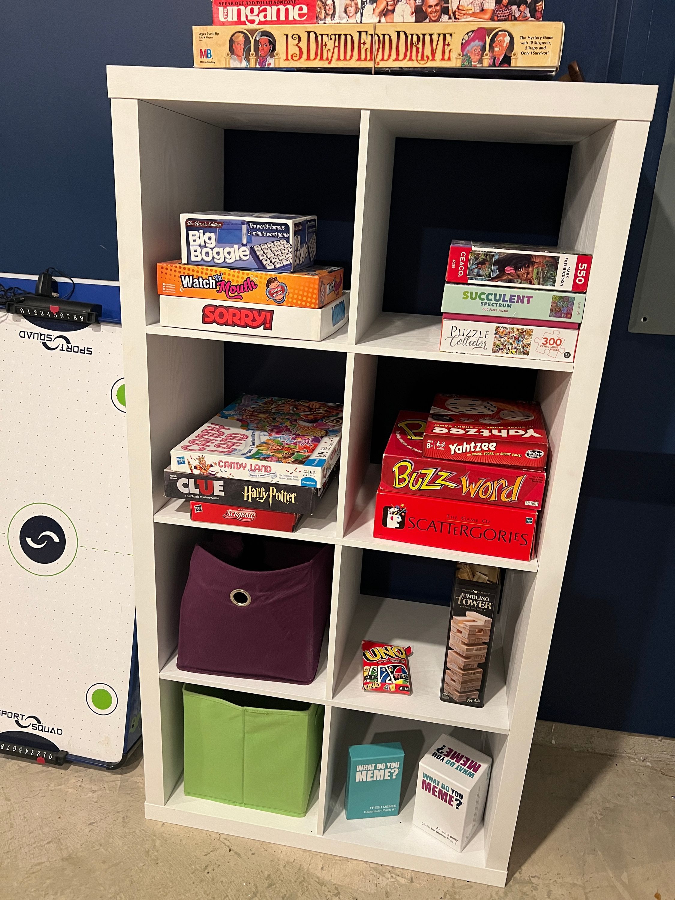 A shelf with various board games and puzzles.