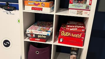 A shelf with various board games and puzzles.