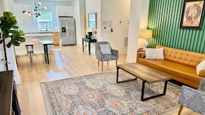 Ein modernes Wohnzimmer mit einer Couch, einem Couchtisch und einem gemusterten Teppich.