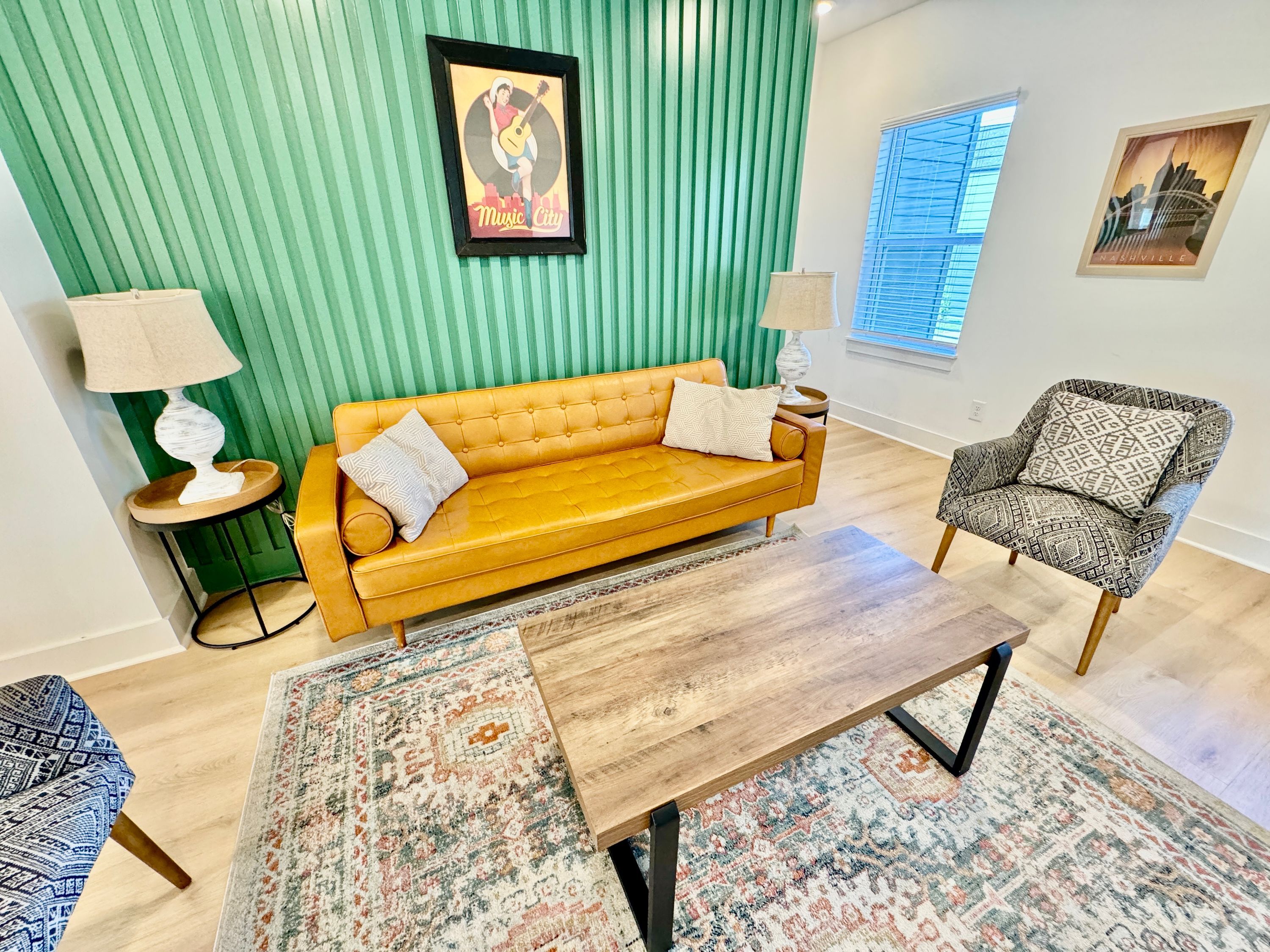 Ein Wohnzimmer mit einem gelben Sofa, einem gemusterten Sessel und einem Holztisch.