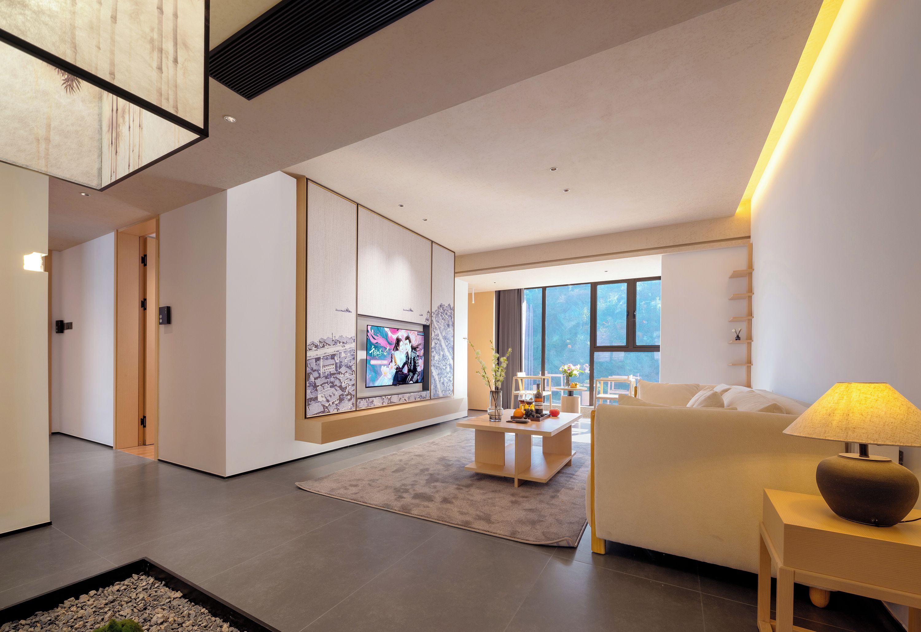 A modern living room with a sofa, a coffee table, and a TV mounted on a wall.