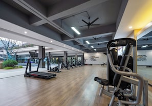 Ein modernes Fitnessstudio mit Trainingsgeräten, einem großen Spiegel und motivierenden Wandtexten.
