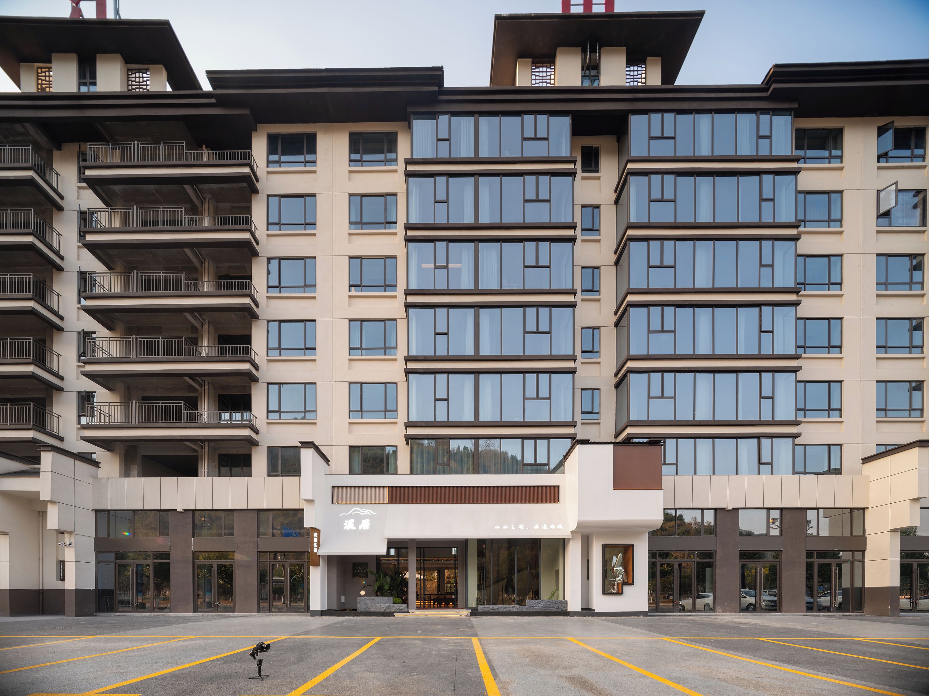 Un hôtel à plusieurs étages, doté d’une façade moderne, de grandes fenêtres et d’une entrée centrale.