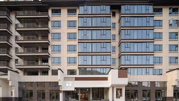 Un hôtel à plusieurs étages, doté d’une façade moderne, de grandes fenêtres et d’une entrée centrale.