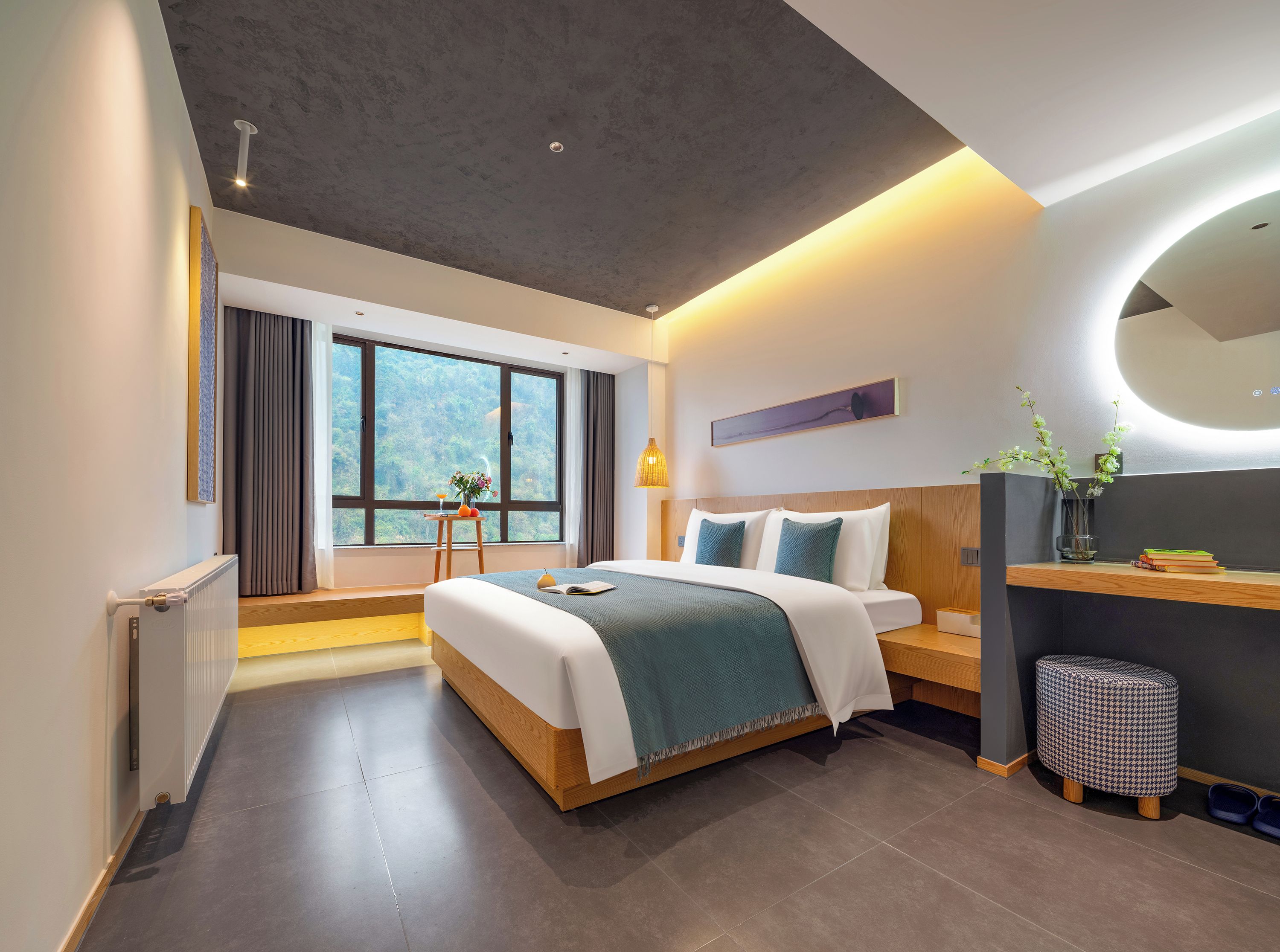 Una habitación de hotel moderna con una cama grande, un escritorio, una silla y vistas al exterior.