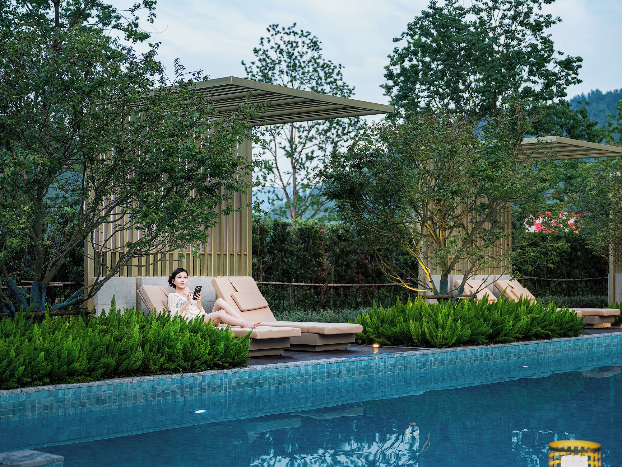 A poolside area with lounge chairs and a pergola.