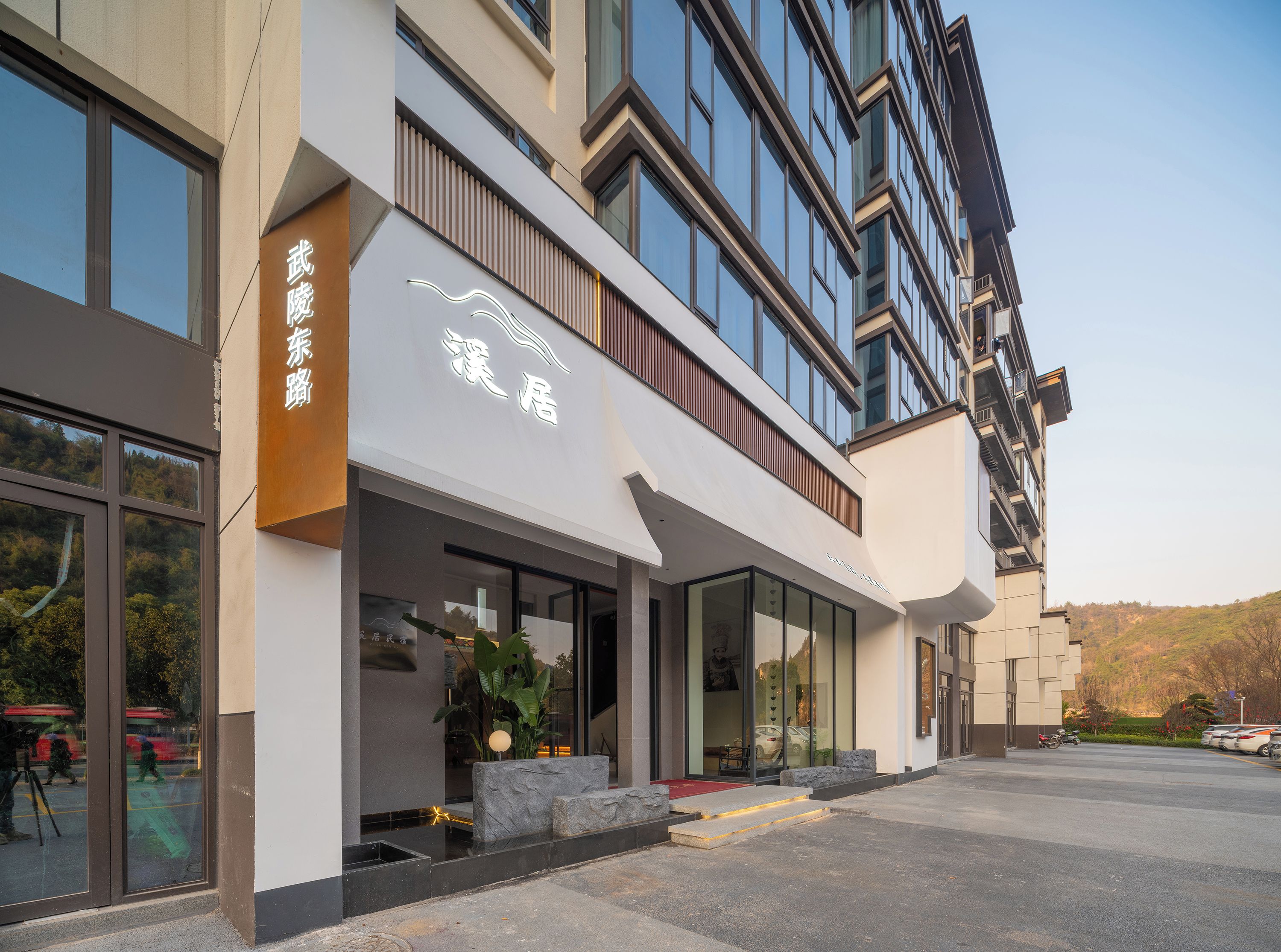 A modern building with large windows and a sign indicating a hotel.