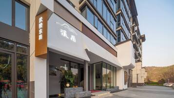 A modern building with large windows and a sign indicating a hotel.