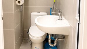 Une salle de bain avec des toilettes, un lavabo et une douche.