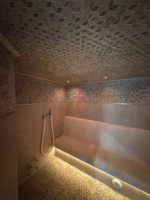 Um banheiro com teto hexagonal e uma banheira, além de uma área com chuveiro.