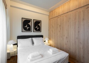 Ein Hotelzimmer mit einem Bett, zwei Nachttischen, einem Schrank und einem Holzschrank.