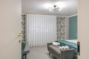 A hotel room with a bed, a chair, a desk, and a curtain. - Room 'Soleil Rooms - Salvia' (Catania)