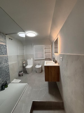 Ein modernes Badezimmer mit Dusche, Toilette, Bidet und Waschtisch.