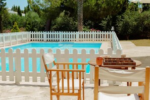 A swimming pool with a white picket fence, surrounded by trees and a clear sky. - Olinda Seaview Villa (Paralimni)