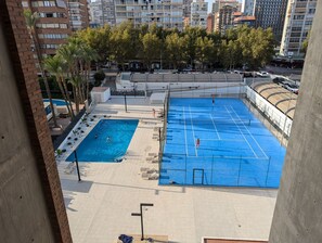 A rooftop tennis court with a pool, surrounded by trees and high-rise buildings. - LOS Gemelos 5B in Benidorm (Benidorm)