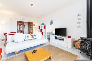 Ein modernes Wohnzimmer mit Sofa, Couchtisch, Fernseher und Kamin.