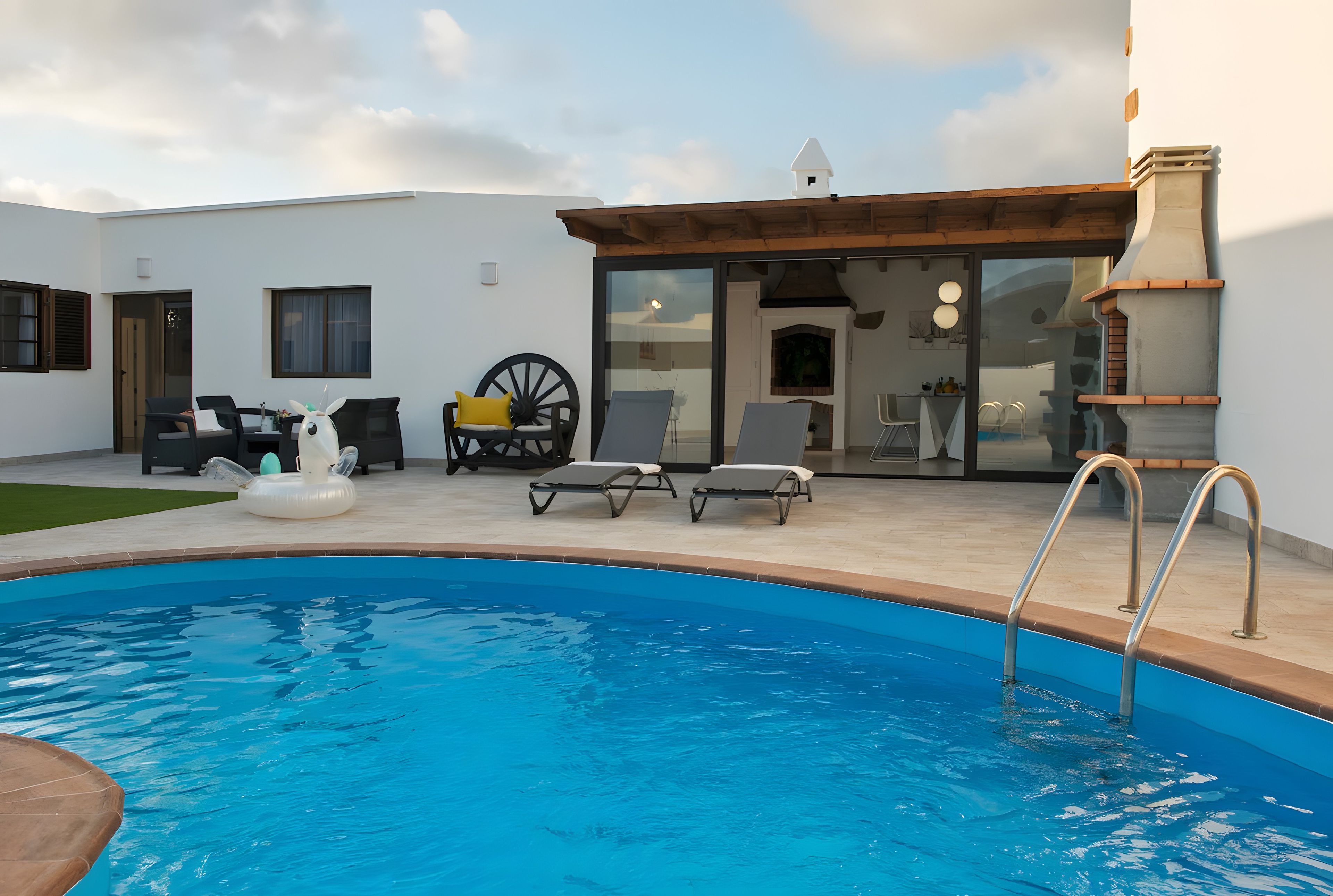 A swimming pool with lounge chairs and a wooden deck.