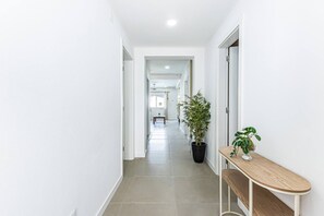 Un pasillo con una planta en maceta y un banco de madera.