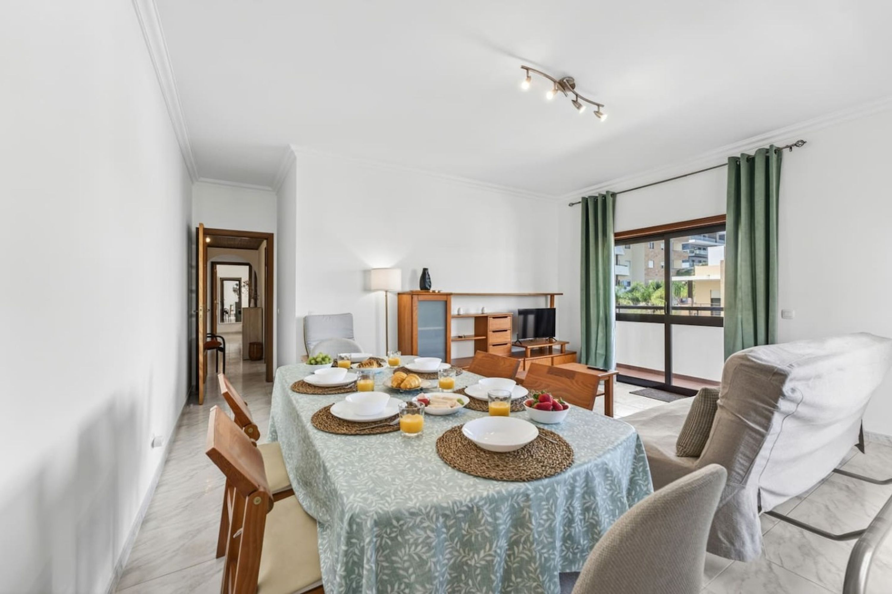 Un coin repas avec une table mise pour le petit-déjeuner, un téléviseur et une vue sur l’extérieur.