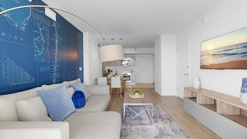 A modern living room with a large map on the wall, a sofa, a coffee table, and a kitchen in the background.