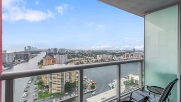 Un balcón con vista a un paisaje urbano, que incluye edificios y un río.