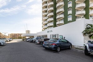 A parking lot with multiple cars and a building with balconies. - Torre Verde Sea View Pool AC (Portimão)