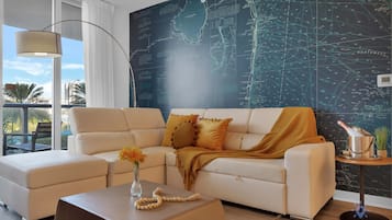 A modern living room with a sectional sofa, a coffee table, and a decorative wall with a map.